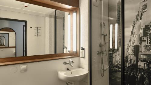 a bathroom with a sink and a mirror at Campanile Prime - Argenteuil in Argenteuil