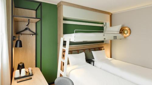 two bunk beds in a room with green walls at Campanile Prime - Argenteuil in Argenteuil