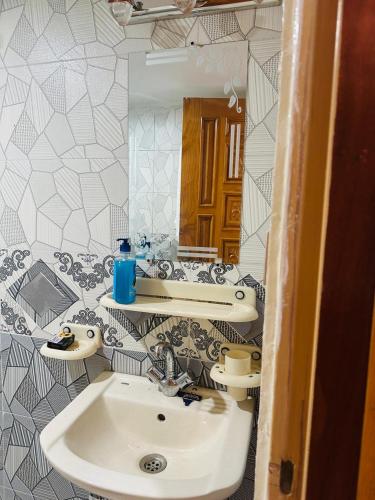 a bathroom with a sink and a mirror at Tabbis Guest House in Islamabad