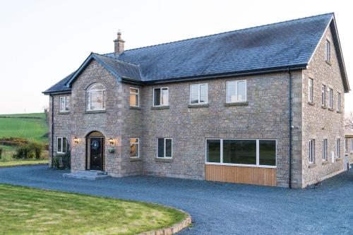 a large brick house with a large driveway at Willow Valley in Monaghan