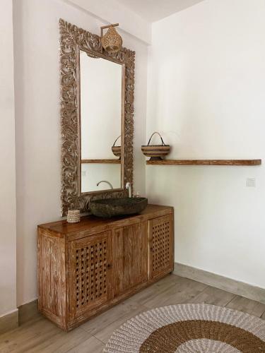 a mirror on top of a wooden dresser in a room at Iru Maldives in Thulusdhoo