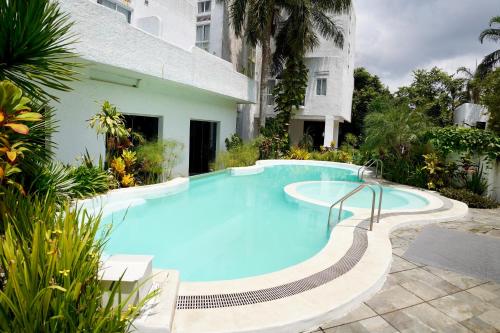 Santorini Lia Soleil at La Bella Tagaytay في Galicias: مسبح ازرق كبير بجانب مبنى