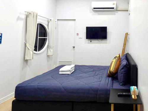 a bedroom with a blue bed and a tv at Cina Home in Chiang Mai