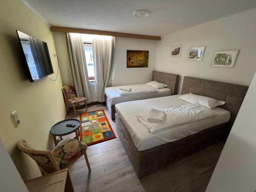 a hotel room with two beds and a television at Hotel Köppeleck in Schönau am Königssee