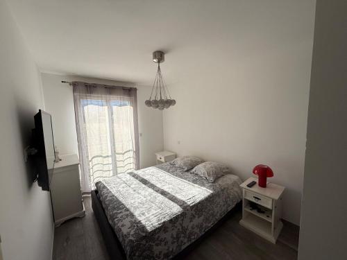 une petite chambre avec un lit et une fenêtre dans l'établissement Confortable T3 10 min plage, à Lucciana