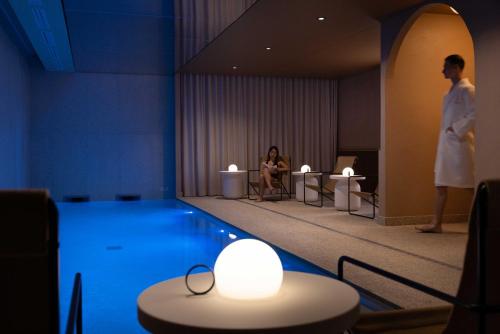 a man standing next to a pool in a hotel room at Belinda Hôtel & Spa in Paris