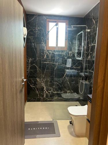 a bathroom with a toilet and a glass shower at Daglas suit in Kannaviou