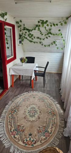 a room with a table and a bench and a rug at Cabana Dara in Cumpăna
