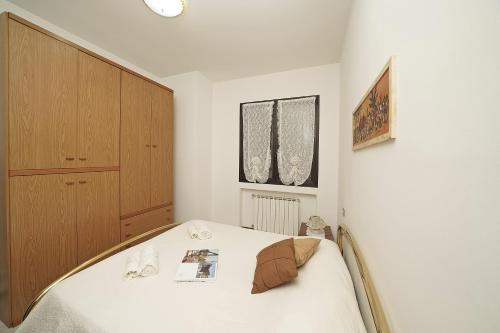 a bedroom with a bed and a cabinet at Il fiordaliso Blu in Desenzano del Garda