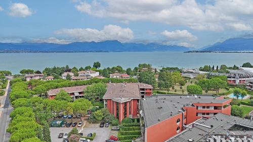 an aerial view of a building with a lake and mountains at Il fiordaliso Blu in Desenzano del Garda