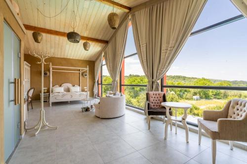a bedroom with a bed and large windows at Hotel Casa Art in Oreshak