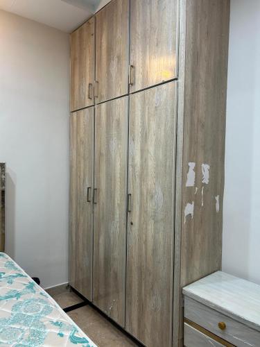 un gran armario de madera en un dormitorio con cama en Quick Guest Houses, en Islamabad