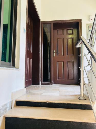una entrada a una casa con una puerta de madera en Quick Guest Houses, en Islamabad