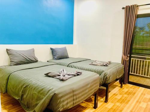 two beds sitting next to each other in a room at Suanvadee Resort สวนวดี รีสอร์ท in Don Sak