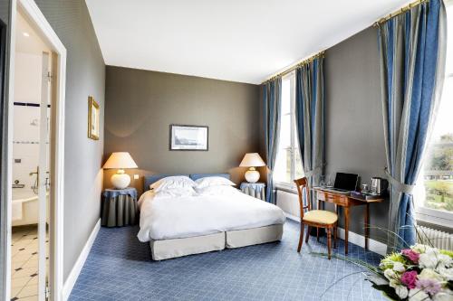 a hotel room with a bed and a desk at Domaine et Golf de Vaugouard - La Maison Younan in Fontenay-sur-Loing