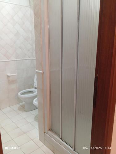 a bathroom with a toilet and a glass shower stall at Le Gemme in Gradoli