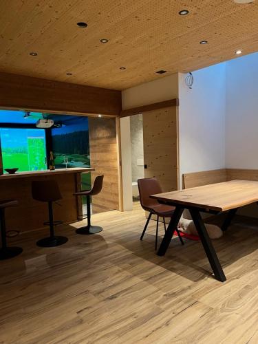 a room with a table and chairs and a bar at Casa Molina in Sedrun