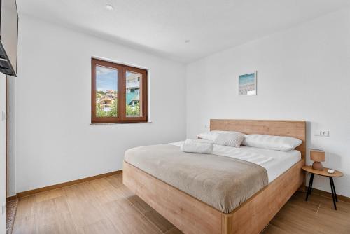 una camera da letto bianca con un letto e una finestra di Villa Paladium a Trogir