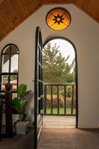 an open door to a porch with a window at ChaletElMuisca RaicesQueAcogen in Nemocón