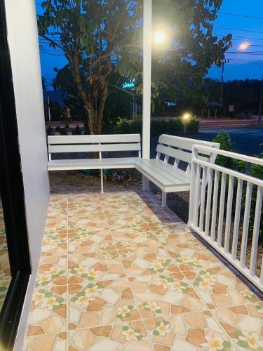 a porch with two benches and a tile floor at Suanvadee Resort สวนวดี รีสอร์ท in Don Sak