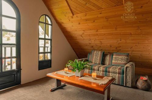 a living room with a couch and a table at ChaletElMuisca RaicesQueAcogen in Nemocón
