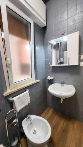 a bathroom with a sink and a toilet and a mirror at La casetta di Totò in Palermo