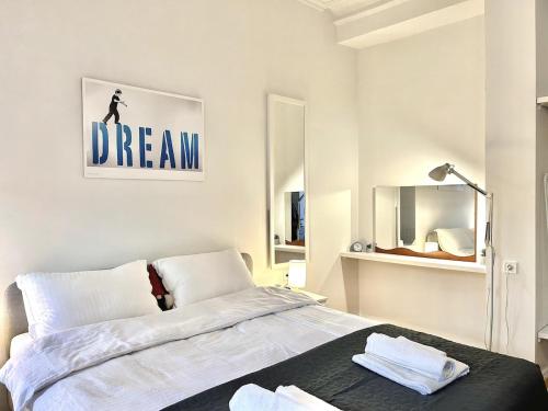 a white bedroom with a bed and a mirror at Dream in Tbilisi City