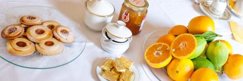 a white table with a plate of oranges and other food at Locanda dei Buoni e Cattivi in Cagliari