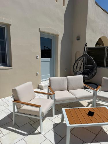 a patio with white couches and a table at Naxos Tower in Naxos Chora