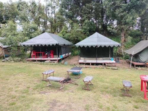 a group of chairs and tents in a field at Namaste Sari in Chopta