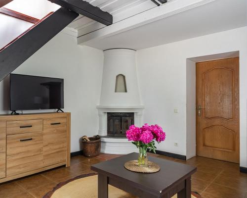 a living room with a vase of flowers on a table at Slėnis Trakuose in Trakai