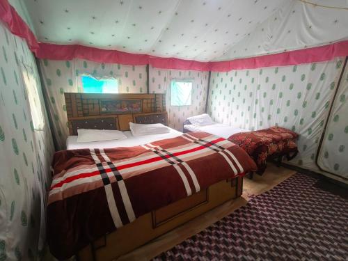 a bedroom with two beds in a tent at Namaste Sari in Chopta
