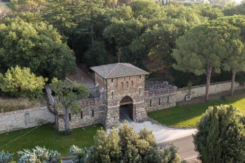 an old stone building with a tunnel in a park at Borgo Dei Conti Resort Relais & Chateaux in Monte Petriolo