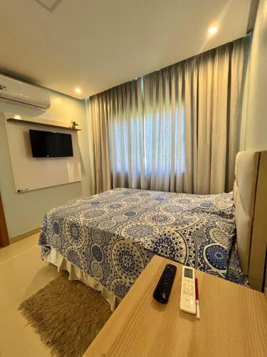 a bedroom with a bed with a remote control on a table at COP30 house in gated community in Ananindeua