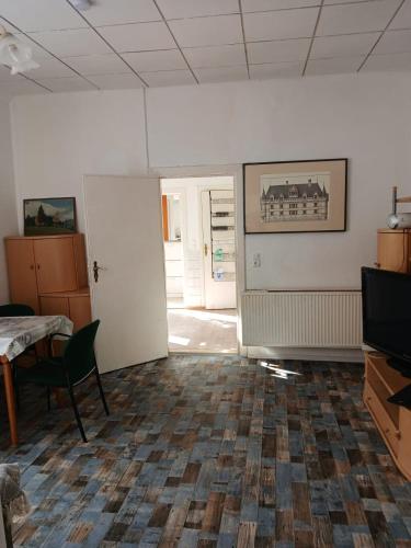 an empty room with a table and a television at Appartement mit Garten zentrumnah in Schwerin