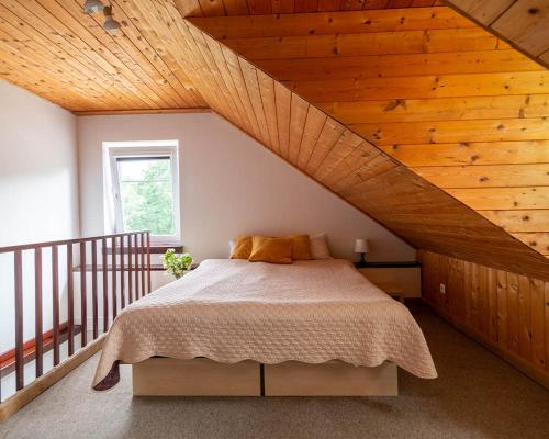 a bedroom with a bed with a wooden ceiling at Slėnis Trakuose in Trakai