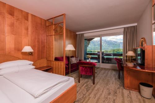a hotel room with a bed and a desk at Hotel Karnerhof in Egg am Faaker See