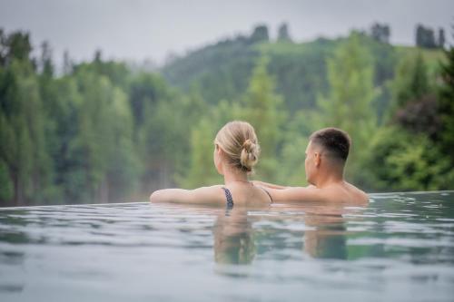 a man and a woman sitting in the water at Königswieser Hof in Königswiesen