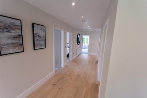 an empty hallway with white walls and wood floors at York - Entire Holiday Home with parking and garden in Nether Poppleton