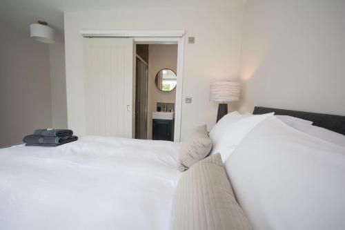 a bedroom with two white beds and a mirror at York - Entire Holiday Home with parking and garden in Nether Poppleton