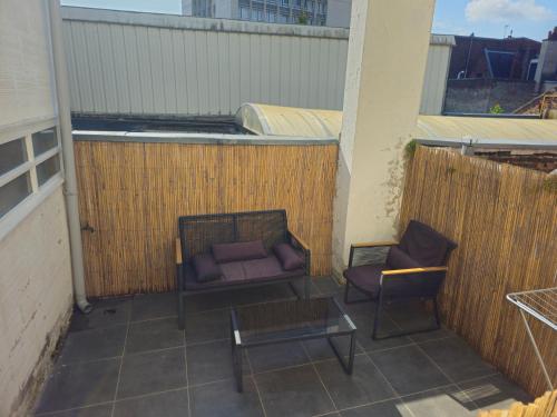 a balcony with a couch and a table and two chairs at Le Grand Place in Arras