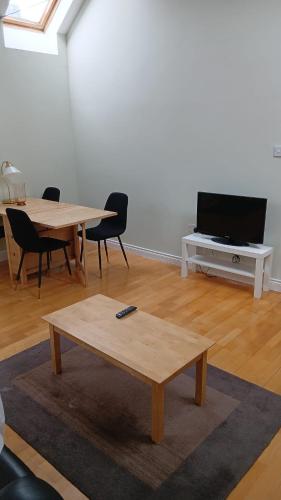a living room with two tables and a flat screen tv at Port Omna Ciúin in Portumna