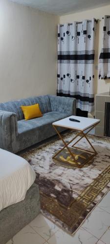 Kitengela にあるThe Unwind Spot Kitengelaのソファとテーブルのあるリビングルーム