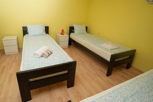 a room with two beds with towels on them at ROLA - smeštaj in Paraćin
