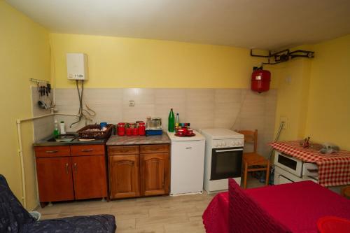 a kitchen with wooden cabinets and a white stove top oven at ROLA - smeštaj in Paraćin