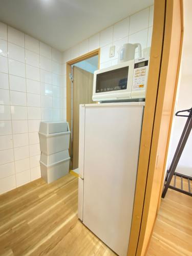 a microwave on top of a refrigerator in a room at The Abe Ikebukuro in Tokyo