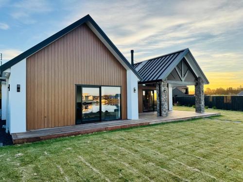 a large house with a deck in a yard at Lake Hood Escape & Private Jetty in Ashburton