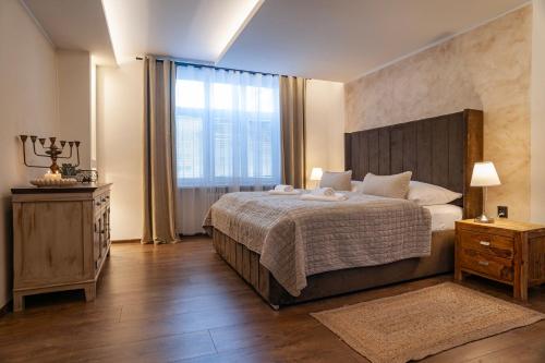 a bedroom with a large bed and a large window at STING Boutique Apartments in Ostrava
