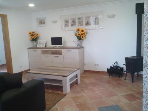 uma sala de estar com uma mesa e um computador no balcão em Casa da Camélia - Sintra em Sintra
