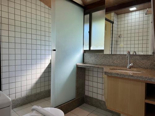 a bathroom with a sink and a mirror at Flat ou Bangalo Luxo Beach Class Beira Mar Muro Alto in Porto De Galinhas